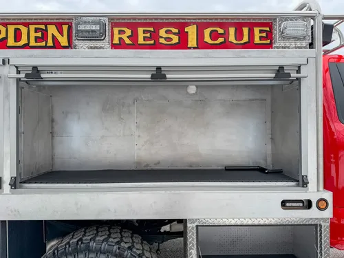 Open mid-side compartment with shelf and empty aluminum interior.